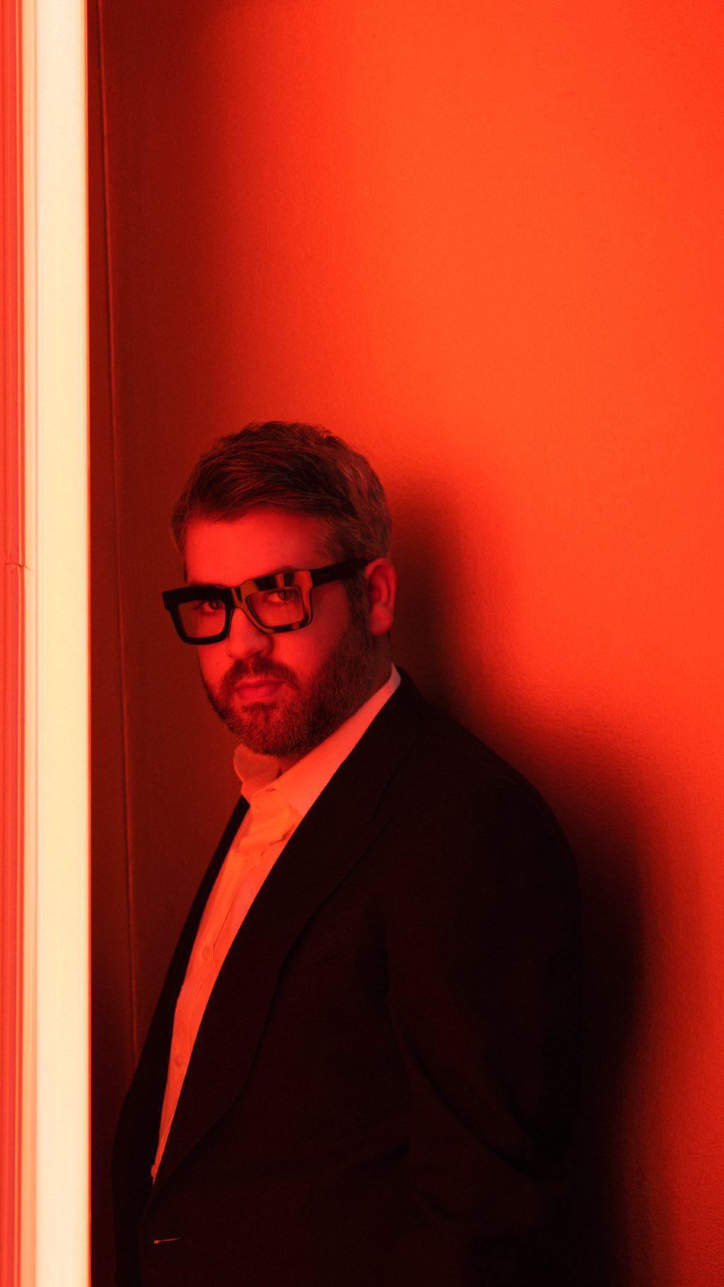Brandon Maxwell standing in a red-lit doorway