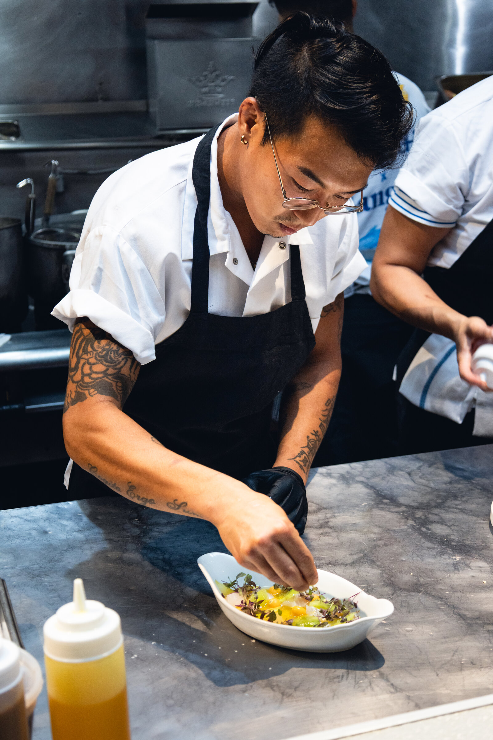A chef finishing a dish in the restaurant kitchen