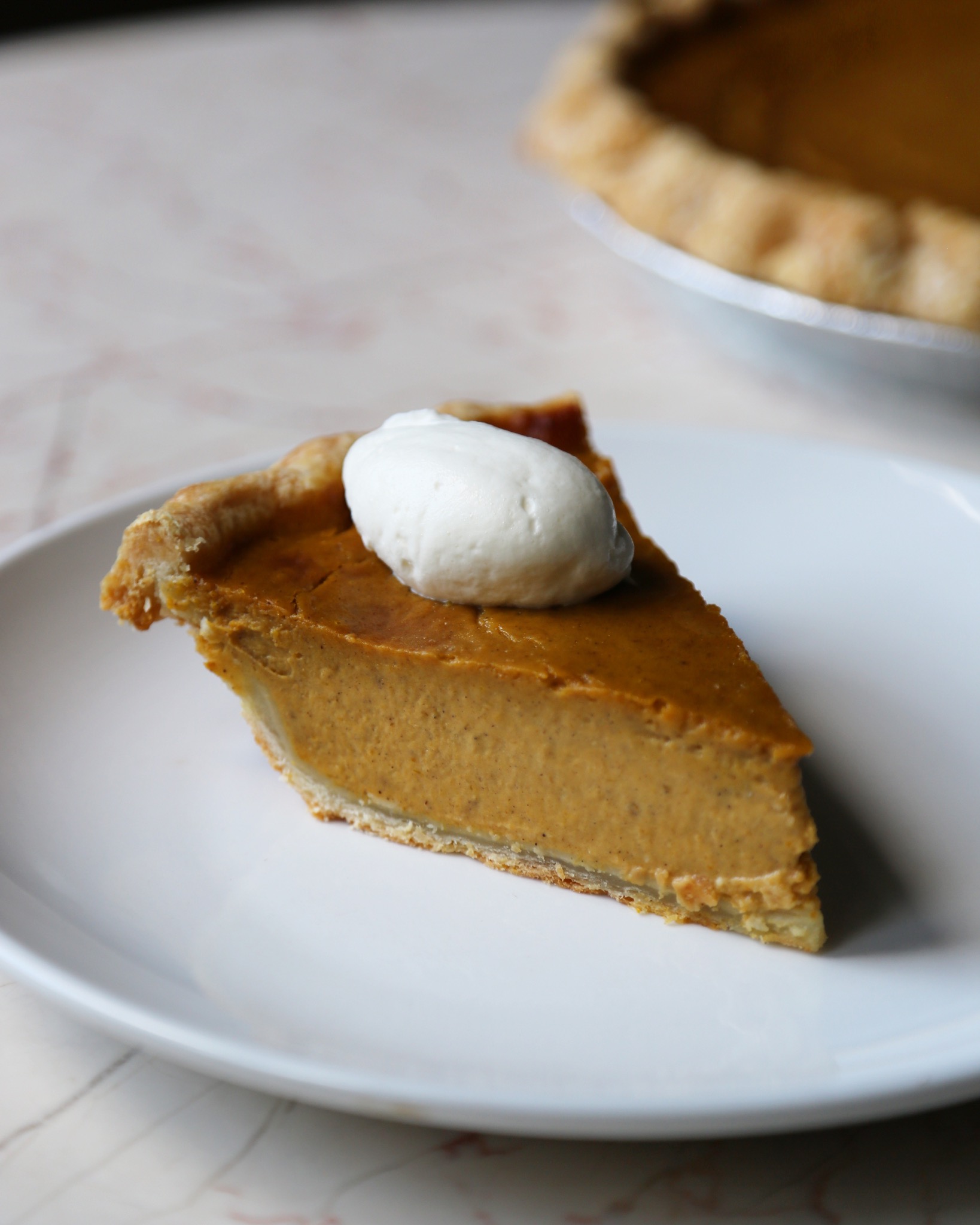 Slice of pumpkin pie with cream