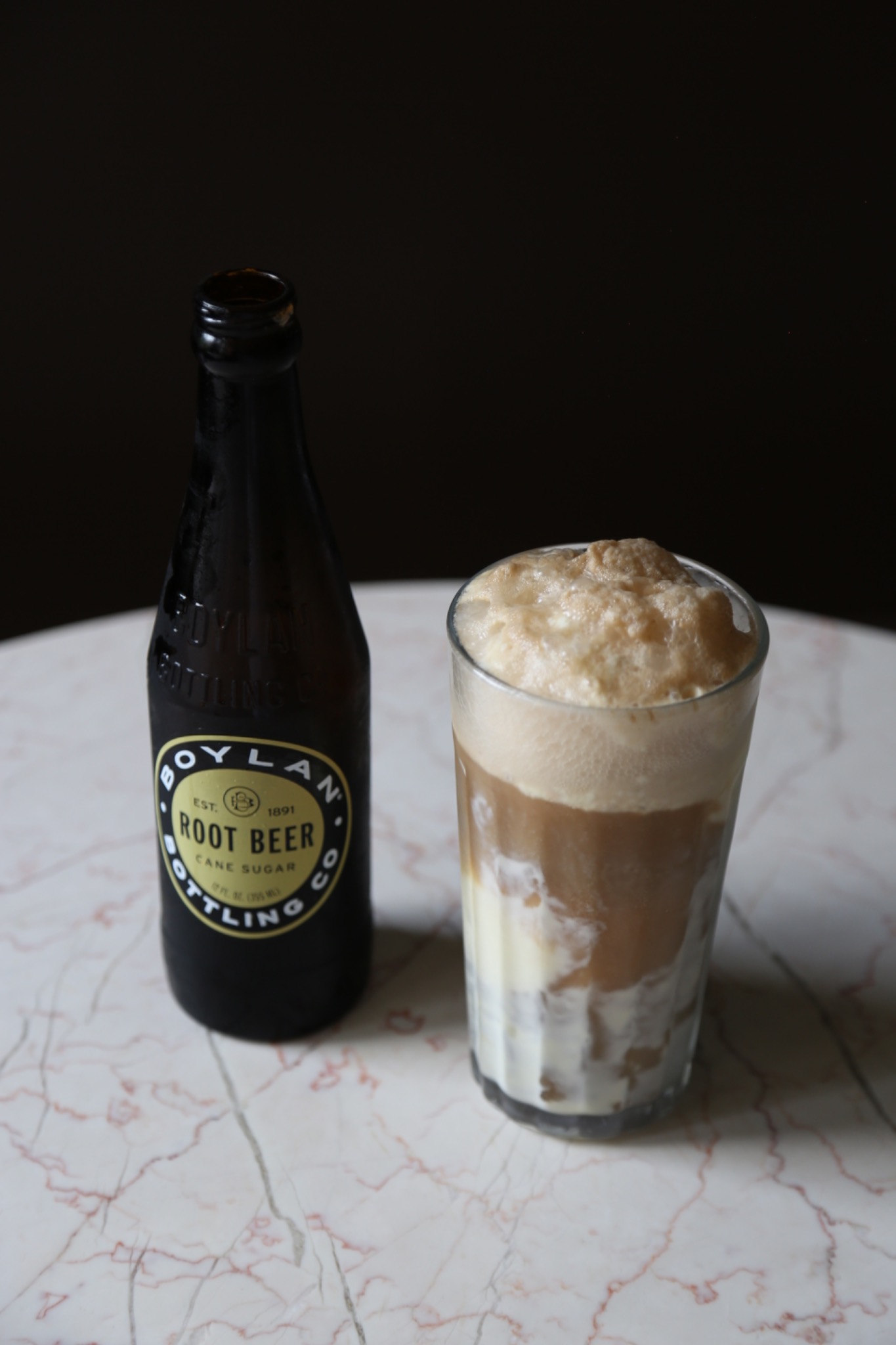 Root beer float beside its bottle