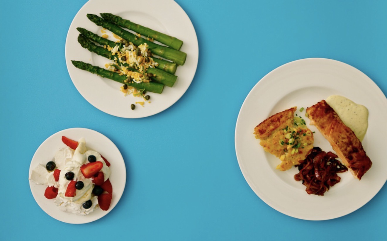 Three plated courses arranged on a vivid blue background