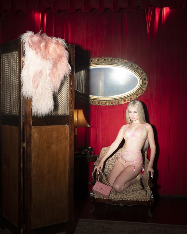 Kim Petras seated in a red curtained room