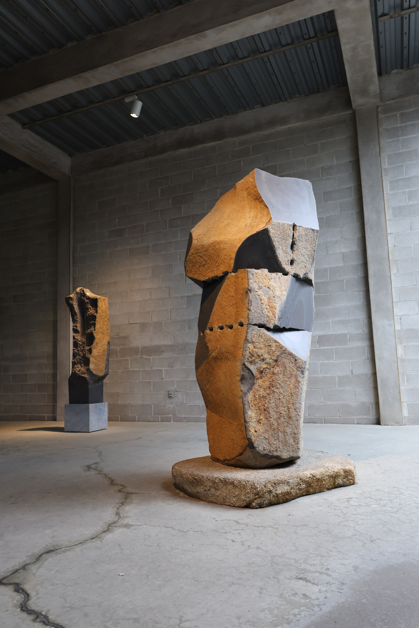 Monumental stacked stone sculpture in a concrete gallery at The Noguchi Museum