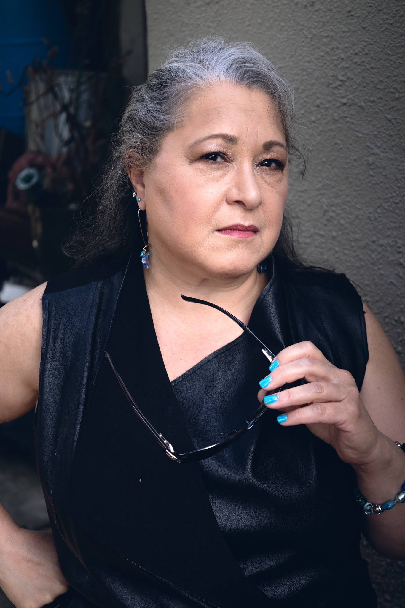 Portrait of Paula Curci holding her glasses
