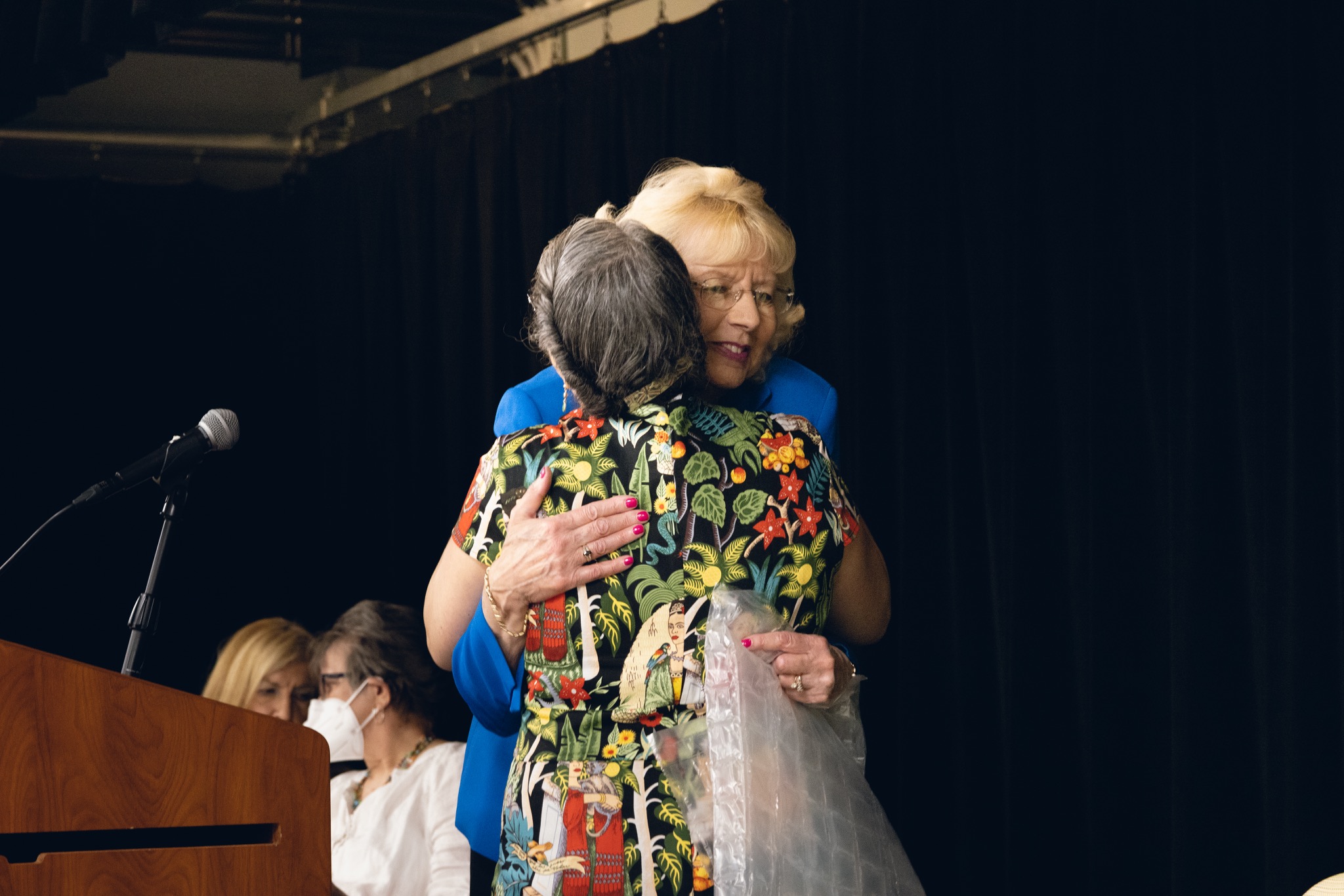 Two guests embrace during the poetry event