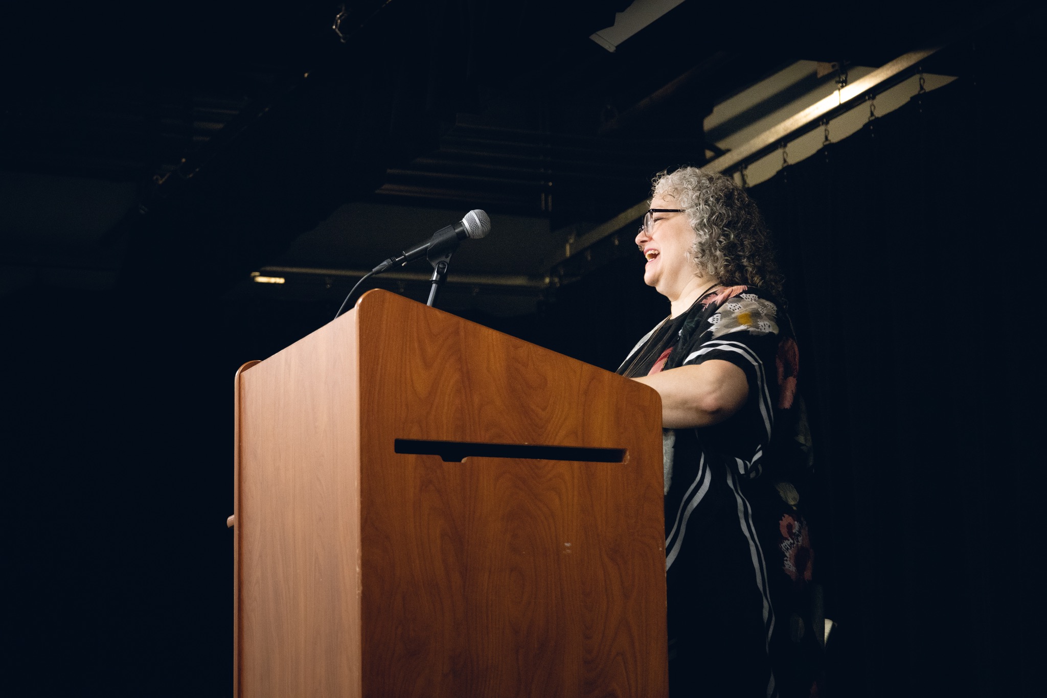 Paula Curci speaking at a poetry event
