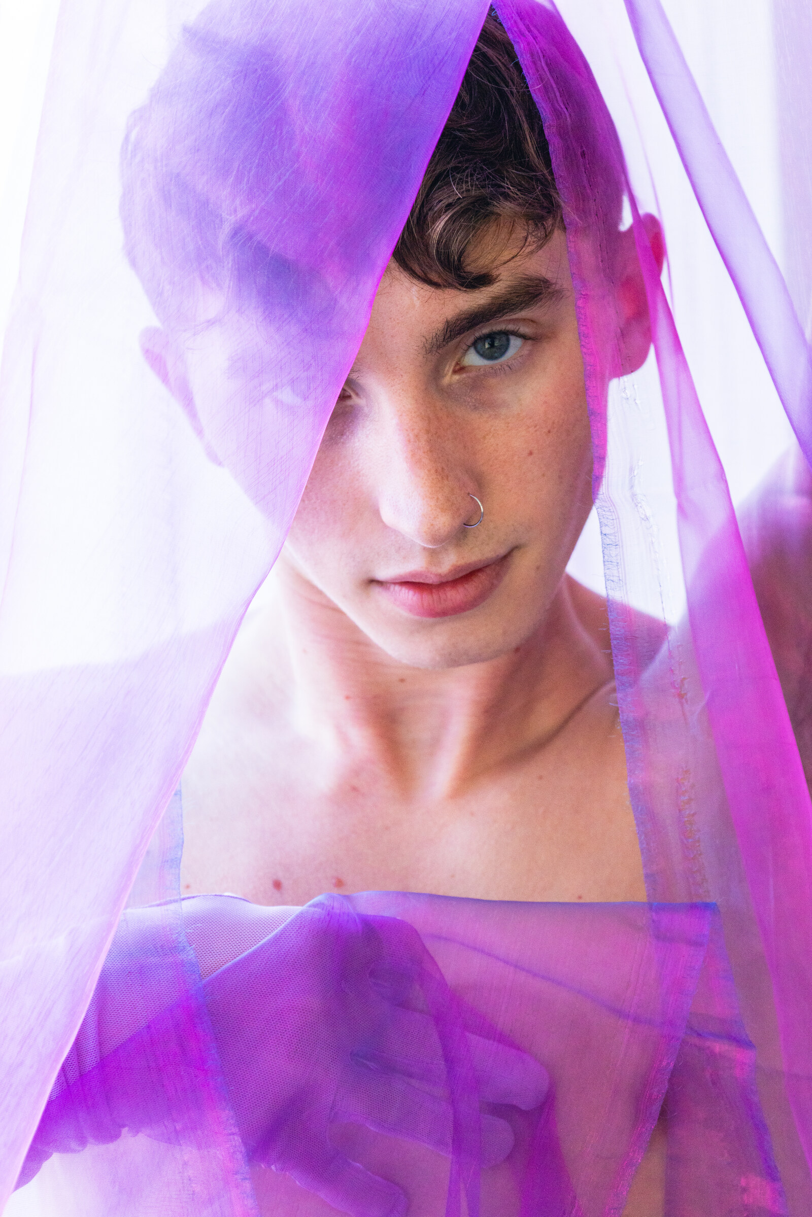 Close portrait of Ryder framed by translucent violet fabric