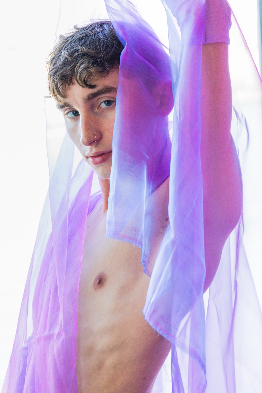 Ryder framed by lengths of violet fabric