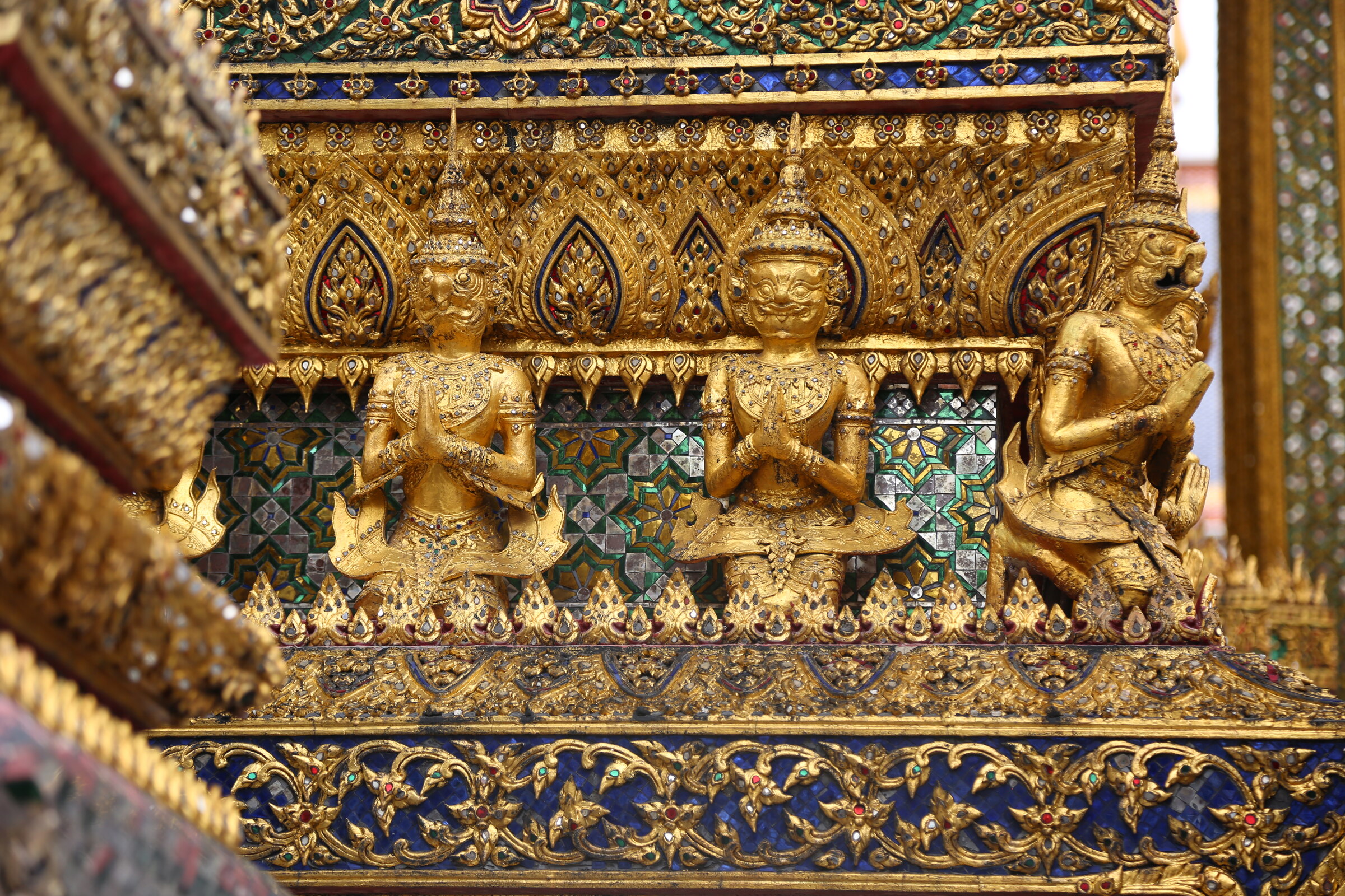 Gilded figures and intricate mosaic ornament at the Grand Palace in Bangkok