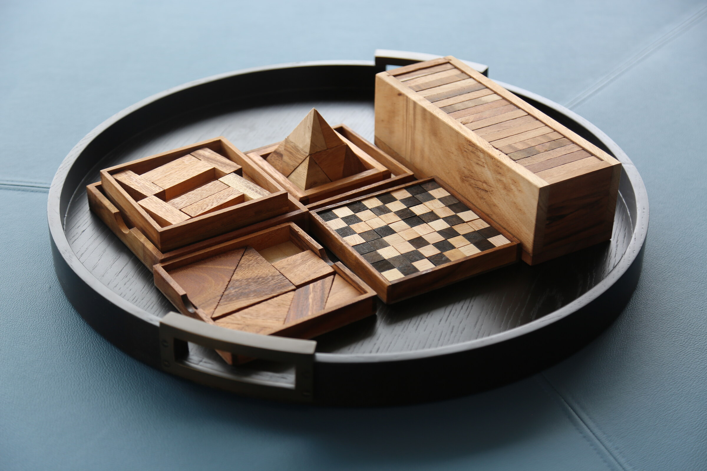 Collection of handcrafted wooden tabletop games arranged on a round tray
