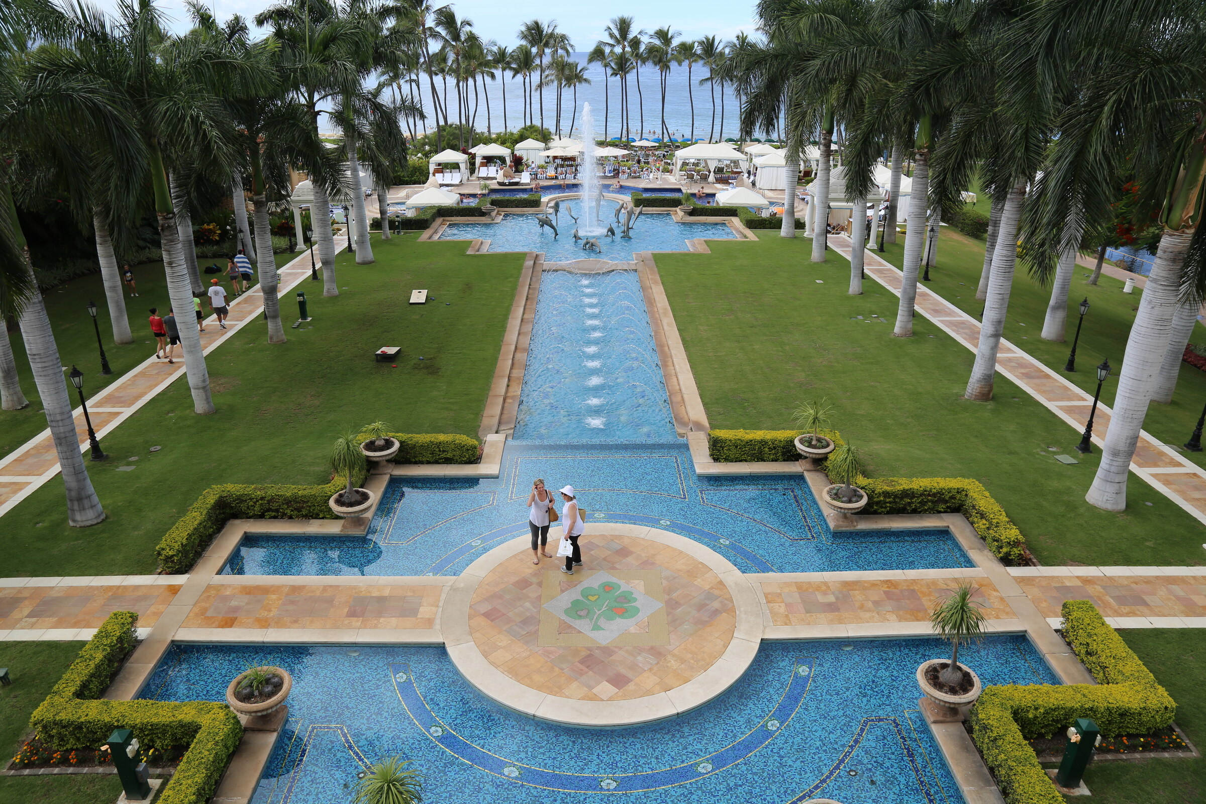 Elevated view across the Grand Wailea pools, palm-lined lawns, and Pacific Ocean in Maui