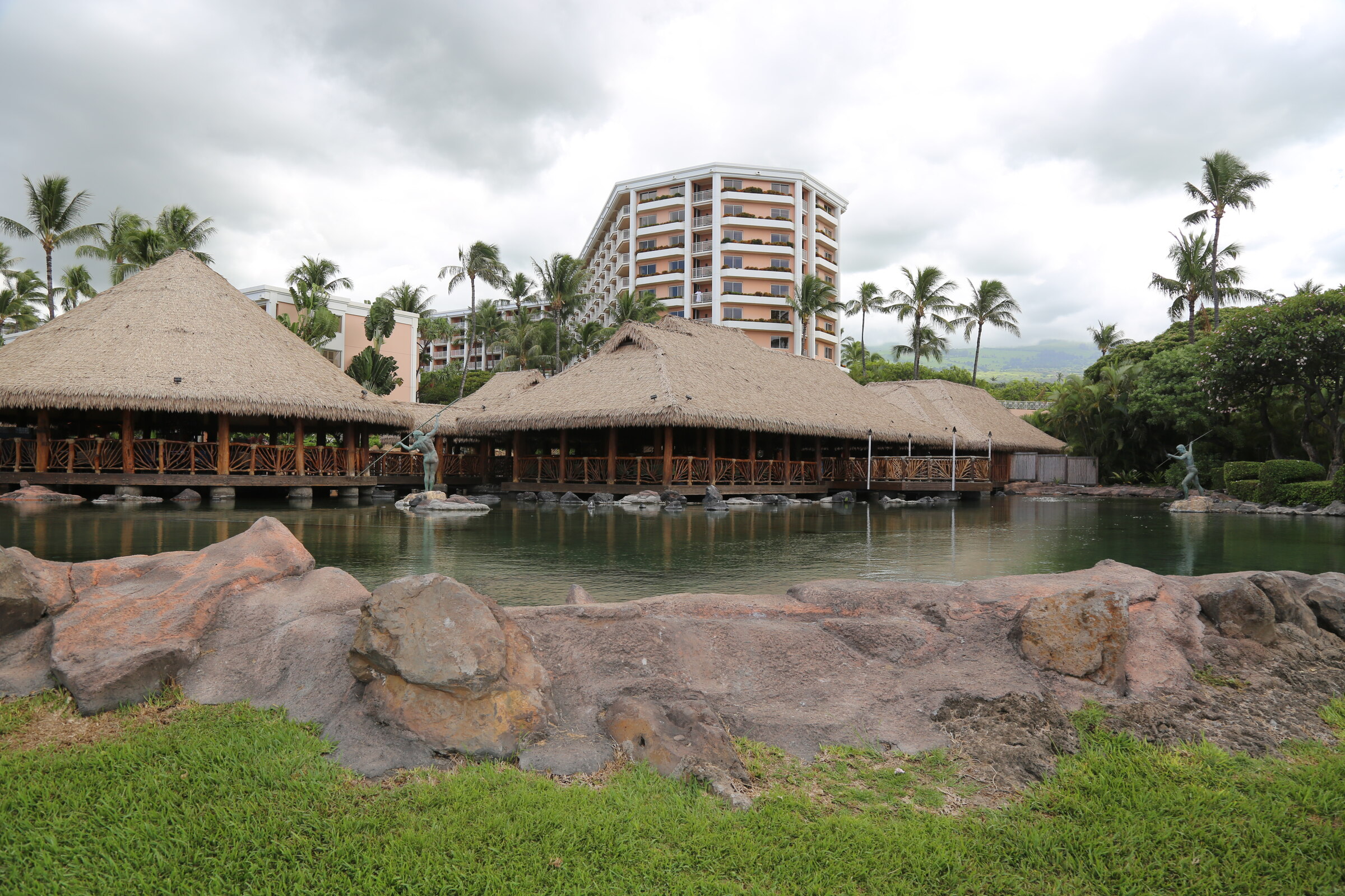 Thatched-roof restaurant beside a lagoon with the Grand Wailea resort beyond