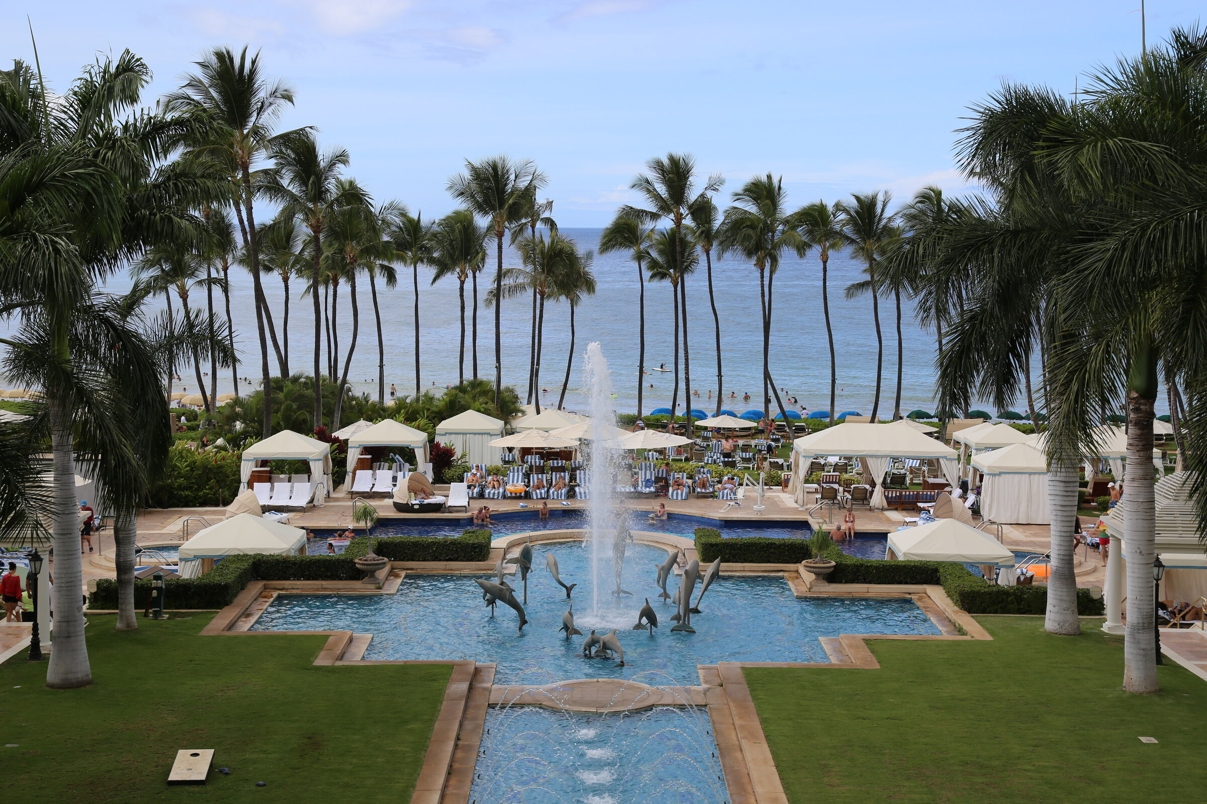 Grand Wailea fountain pool framed by palm trees with the Pacific Ocean beyond